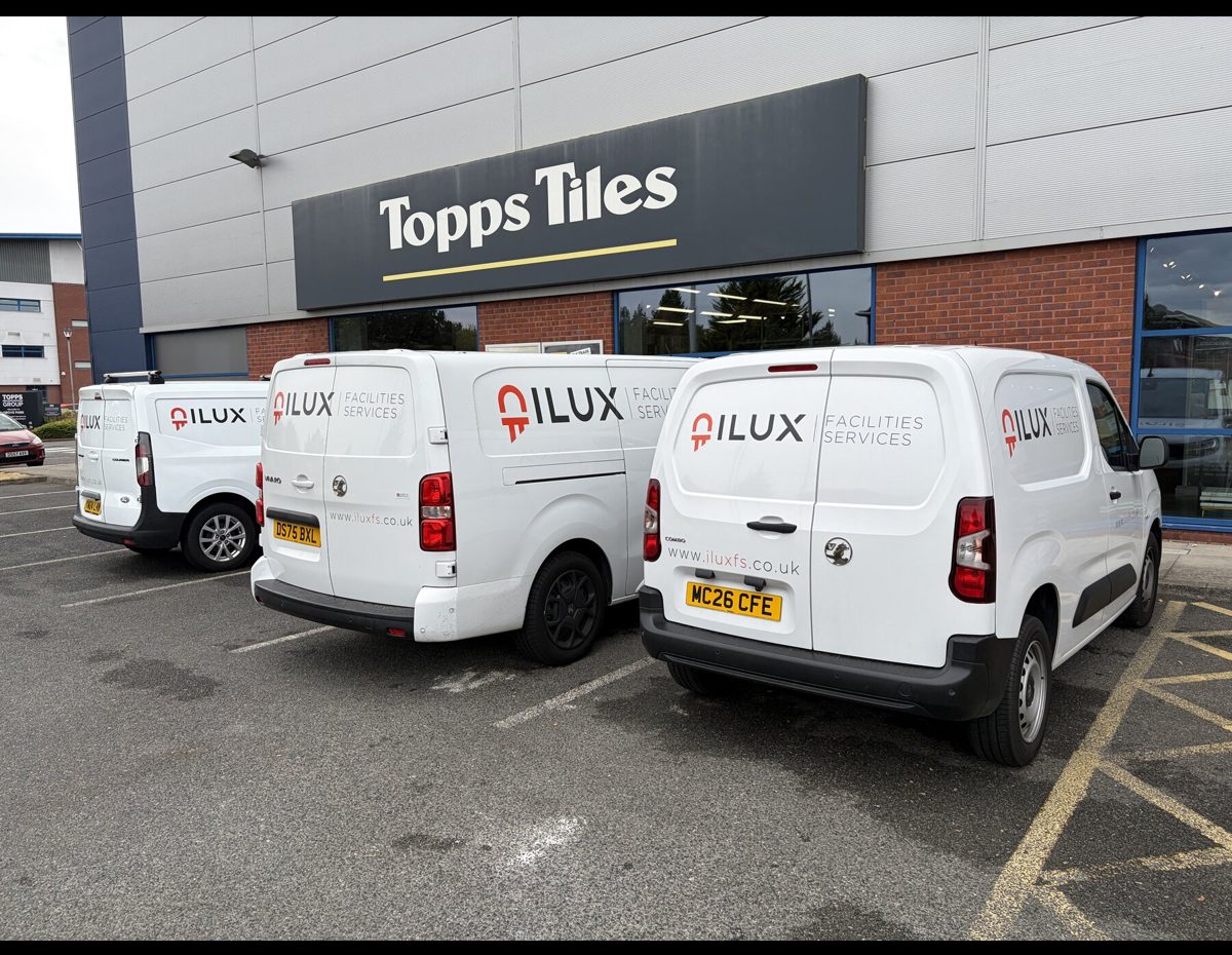 ILUX vans parked outside a client store